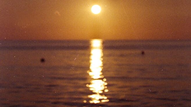 Person Looking at Sunset over Sea